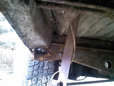 Drivers side frame in front of water pipe behind wheel